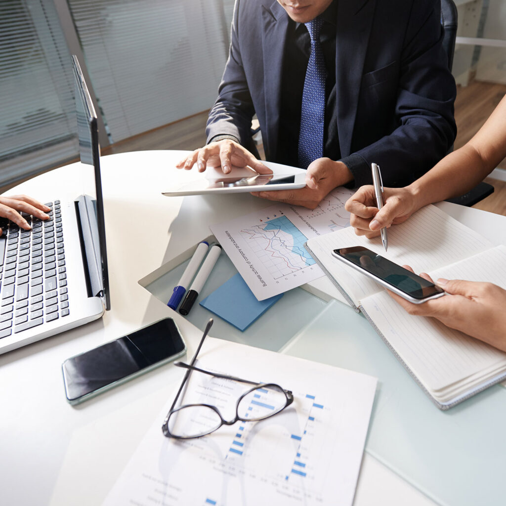 Equipo de profesionales analizando datos y documentos financieros para la toma de decisiones empresariales.